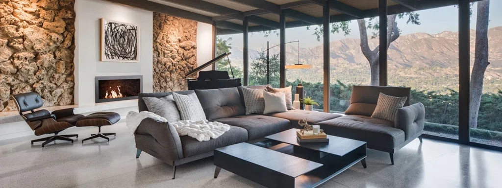 HartmanBaldwin Robin Residence Mid-Century Living Room Renovation - Hartman Baldwin Mid-century modern living room with grey and black furniture, a fireplace, and a mountain range out the window.