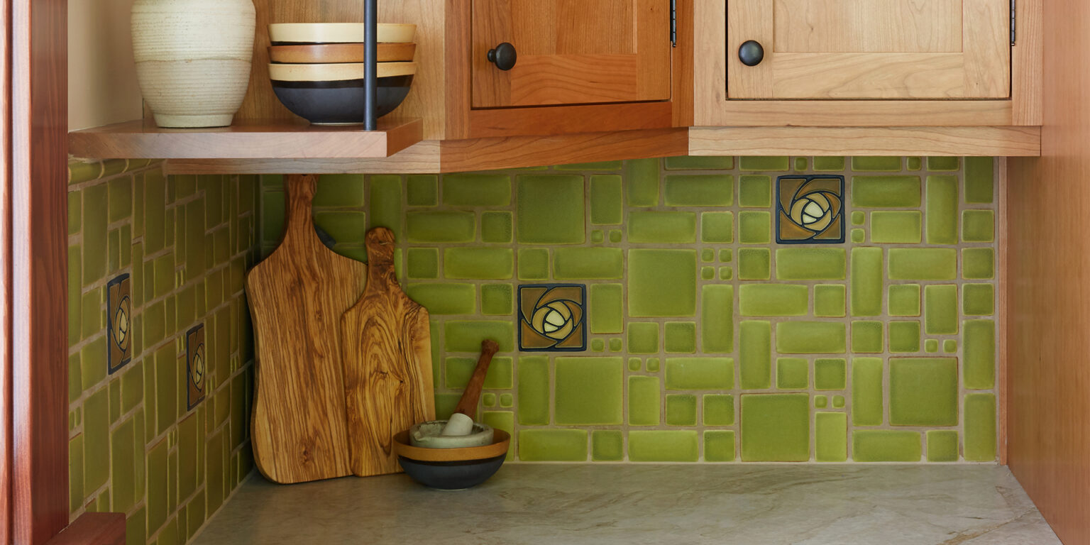 Kitchen remodel with wood cabinets, green back splash, and granite countertops.