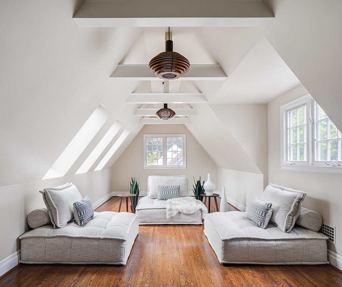 A-frame sloped English cottage style bedroom interior remodel including three lounge beds, vaulted ceilings, and large windows.