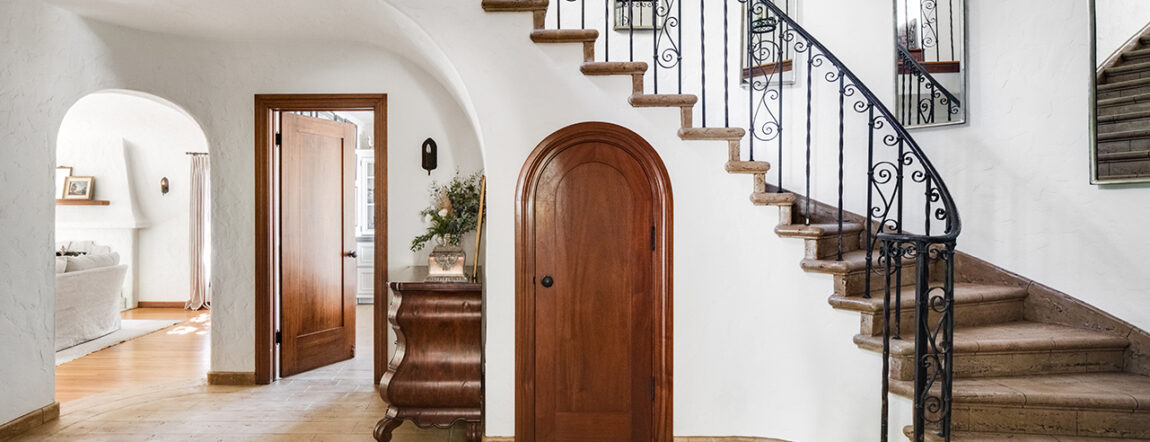 Entryway with spiral staircase, coat closet, and hallway table