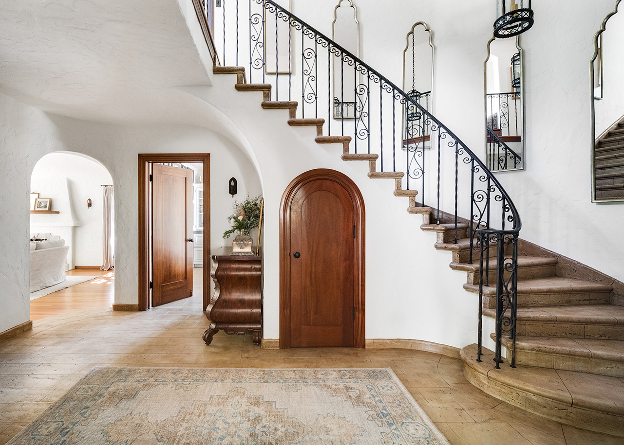 Entryway with spiral staircase, coat closet, and hallway table