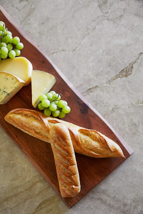 Charcuterie board on cream stone countertop with elegant veining