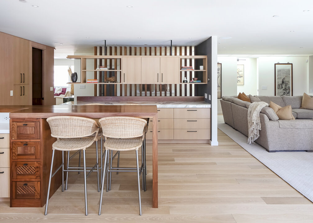 Stylish kitchen with fine wood cabinets and island and a living room, remodeled with a design/build firm.