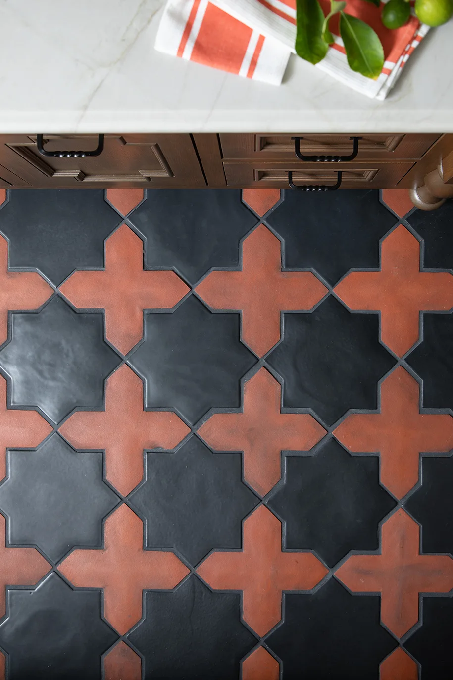 Star-and-cross patterned red and black terracotta kitchen flooring