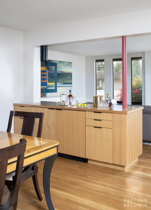 HartmanBaldwin Oak Knoll Residence Mid-Century Modern Bar Cabinet - Hartman Baldwin Mid-Century Modern built-in wine refrigerator cabinet with slab-style oak cabinetry and red painted supportive column