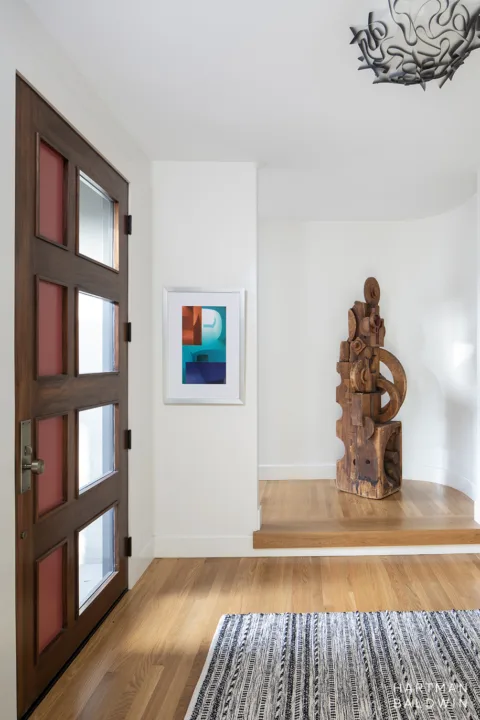 HartmanBaldwin Oak Knoll Residence Mid-Century Modern Foyer with Rug - Hartman Baldwin Mid-Century Modern foyer with artistic paneled front door and abstract wooden sculpture