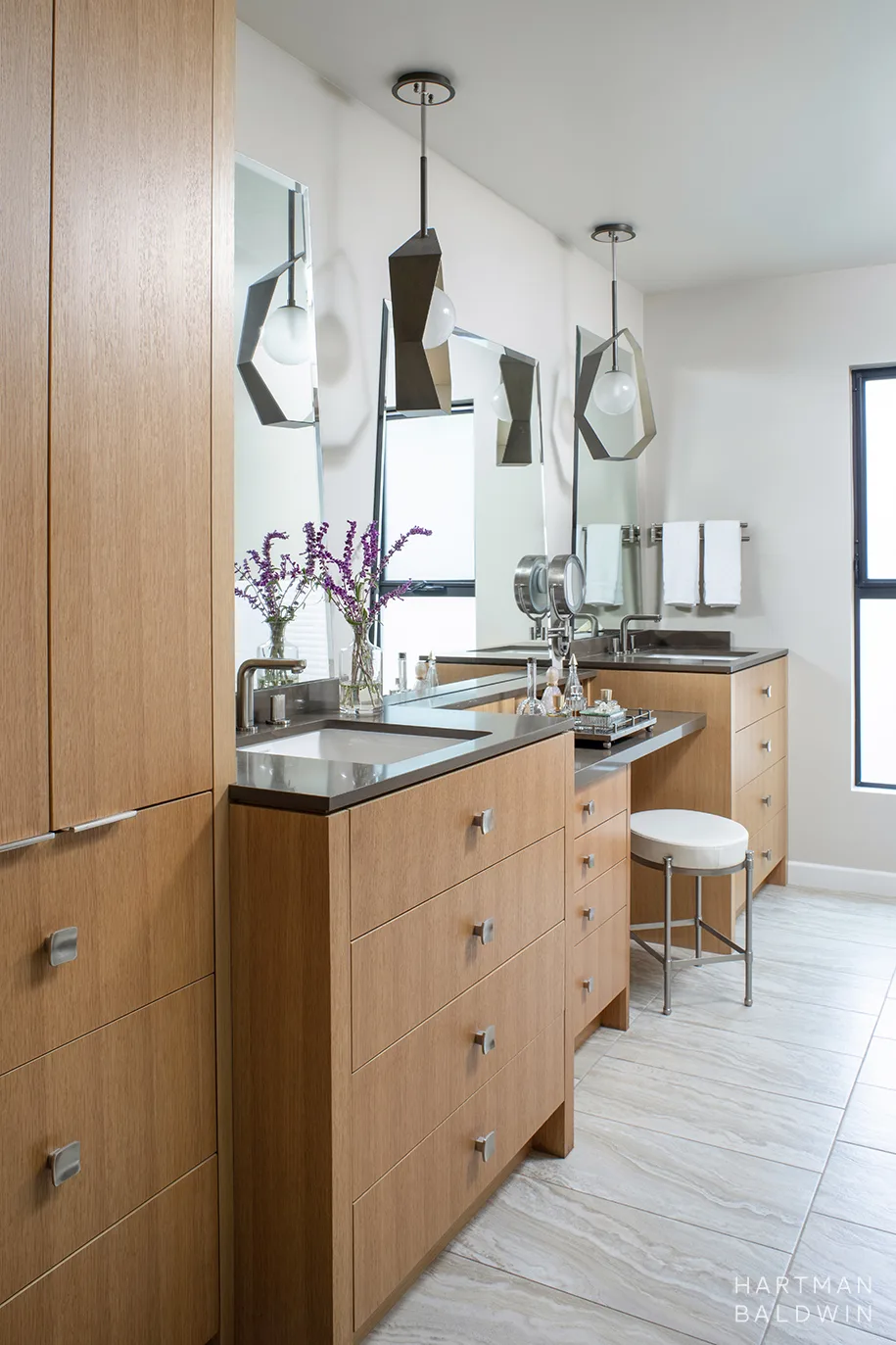 Remodeled Mid-Century Modern primary bathroom vanity with plenty of quality storage and unique geometric light pendants