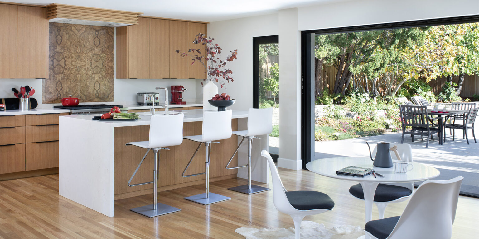 Renovated Mid-Century Modern kitchen and dining room with wide sliding glass doors open to the backyard
