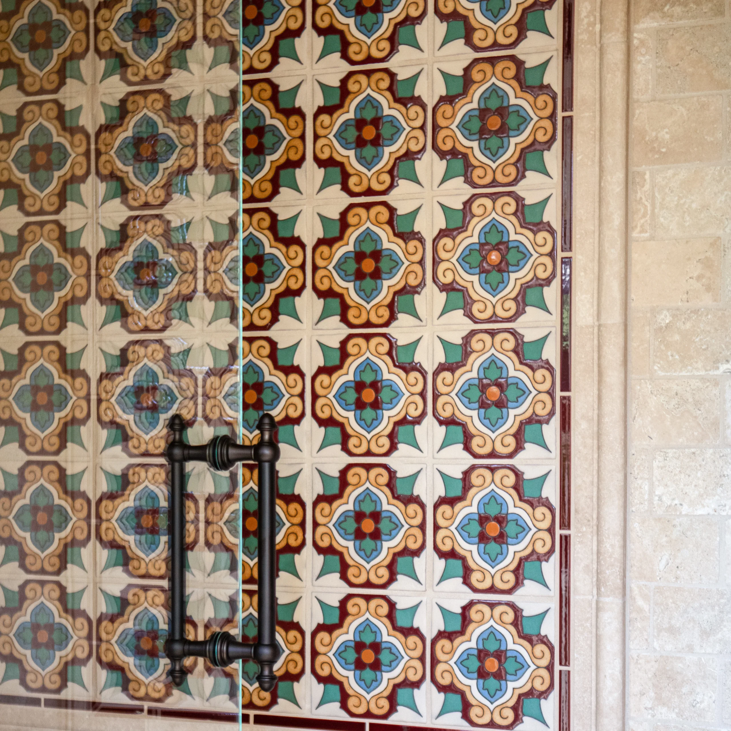 Spanish-style geometric decorative shower tile in cream, red, teal, orange and blue