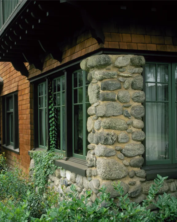 HartmanBaldwin College Residence Craftsman Style Exterior Material Details - Hartman Baldwin Craftsman-style home exterior details including stained-wood shingles, cobblestone pillar, divided light windows, and lush green landscaping