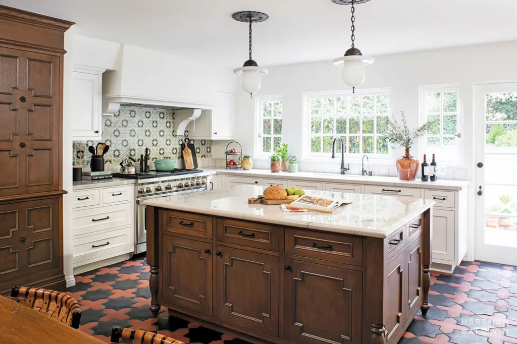 HOLLYWOOD HILLS HartmanBaldwin Ledgewood Residence Spanish Style Kitchen - Hartman Baldwin Remodeled Spanish-style kitchen with colorful geometric floor and backsplash tile, dark-stained furniture-style island and pantry, and bright white perimeter cabinetry