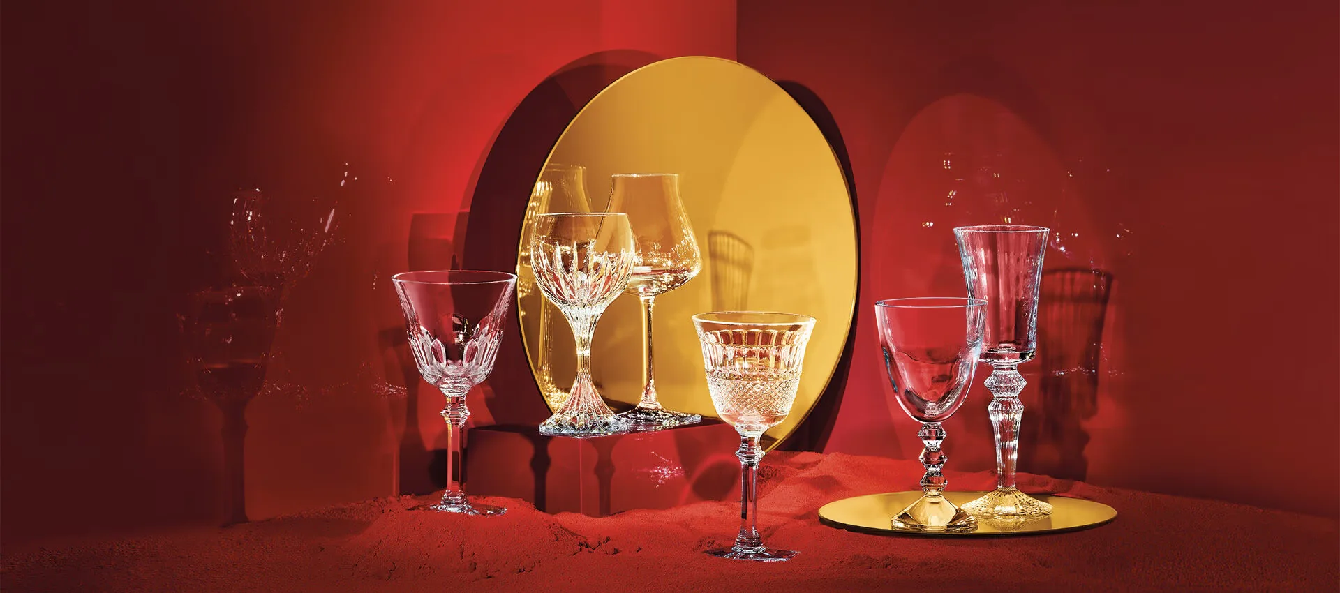 Decorative crystal wineglasses in front of red and gold background