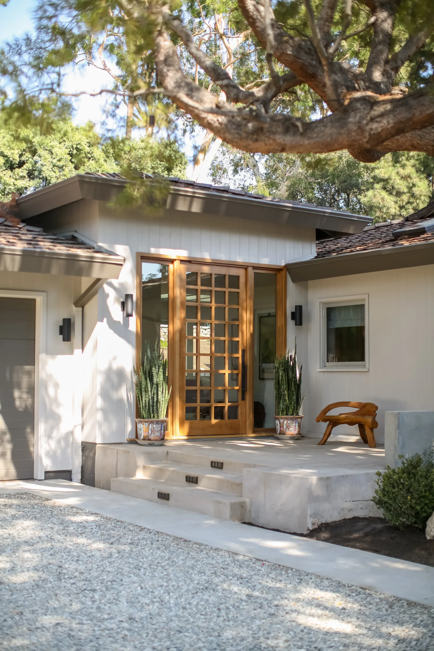 Remodeled modern Zen-inspired home front porch with large wood and glass front door