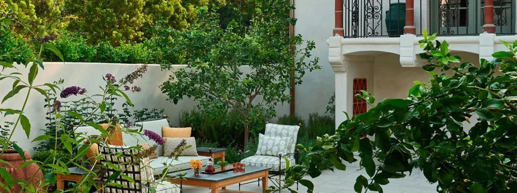 Restored California Italianate-style home surrounded by lush landscaping and an adjacent furnished patio