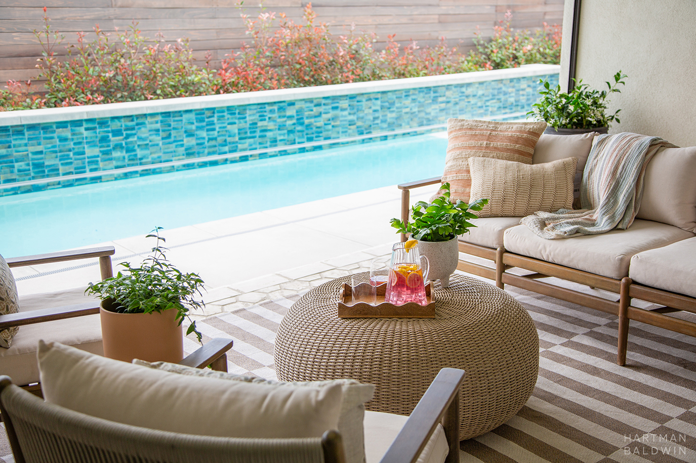 Furnished California room patio with new tiled backyard lap pool seen beyond