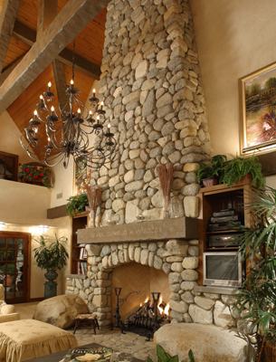 HartmanBaldwin Pomello Residence Guest House Fireplace Floor to ceiling lit cobblestone fireplace inside English Tudor-style ADU guest house