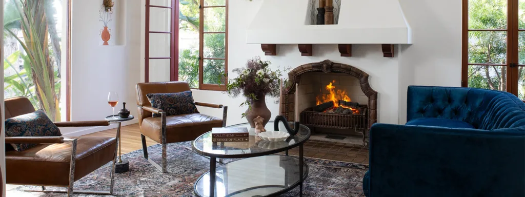 Remodeled Spanish-style living room with a fireplace and blue velvet couch