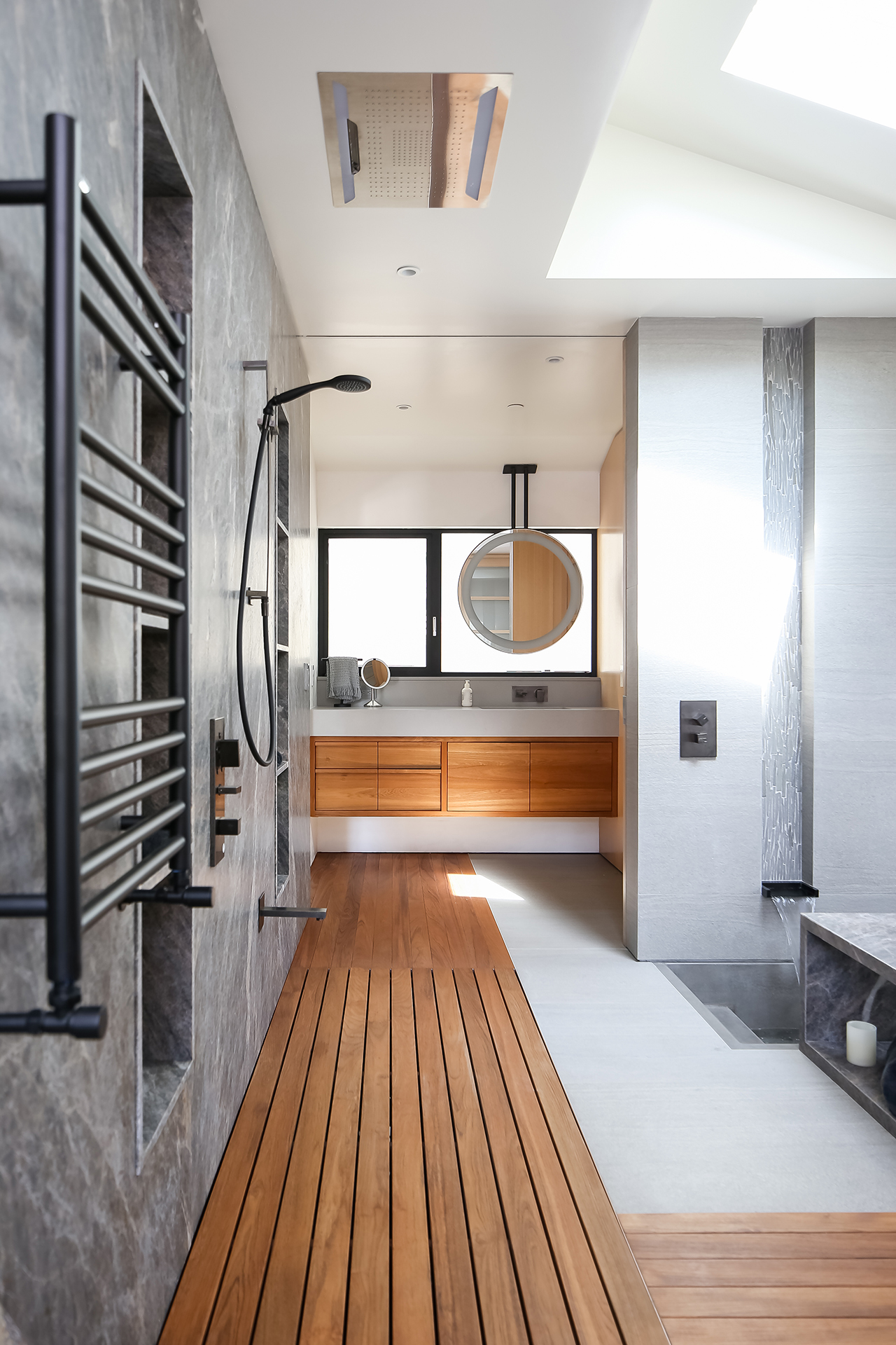 Sleek and modern Zen-inspired primary bathroom with open shower, teak accents, and sunken concrete tub